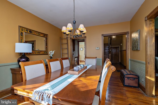 dining area featuring a chandelier, wood finished floors, and baseboards