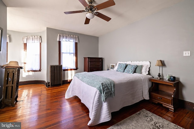 bedroom with radiator, hardwood / wood-style flooring, baseboards, and ceiling fan
