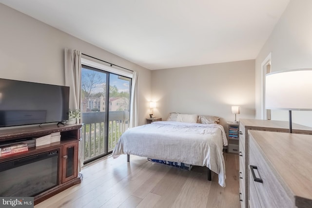 bedroom with access to exterior and light wood-style flooring