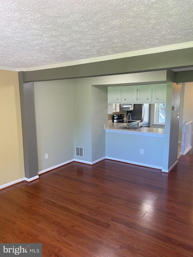 unfurnished living room with a textured ceiling, dark wood finished floors, baseboards, and crown molding