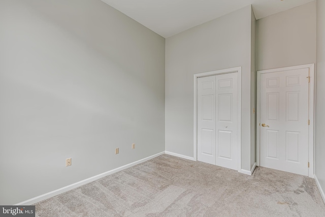 unfurnished bedroom with a closet, baseboards, and carpet flooring