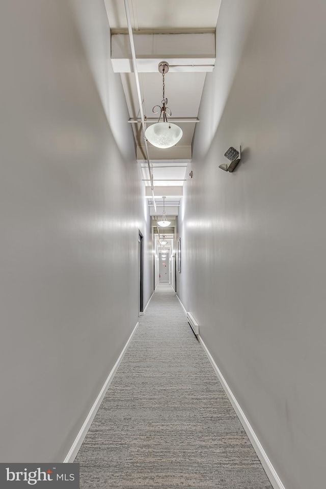 hall featuring a baseboard radiator, carpet, and baseboards