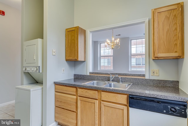 kitchen with dishwasher, a sink, dark countertops, a chandelier, and stacked washing maching and dryer