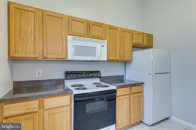 kitchen featuring light tile patterned floors and white appliances