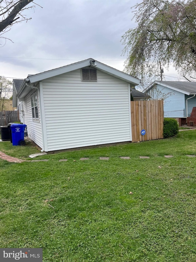 view of side of property with fence and a lawn