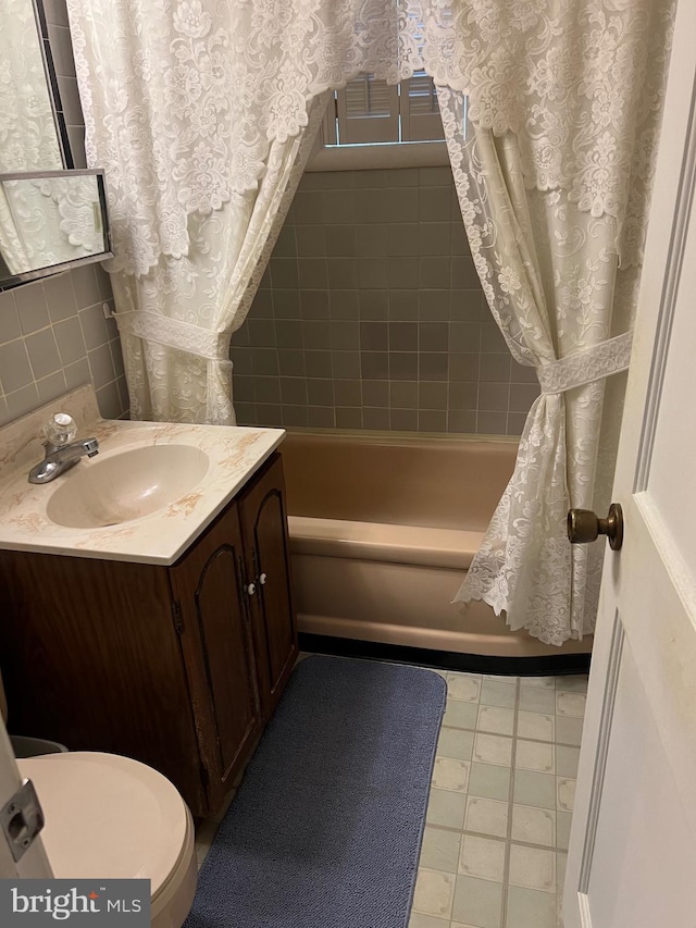 bathroom featuring toilet, shower / tub combo, and vanity