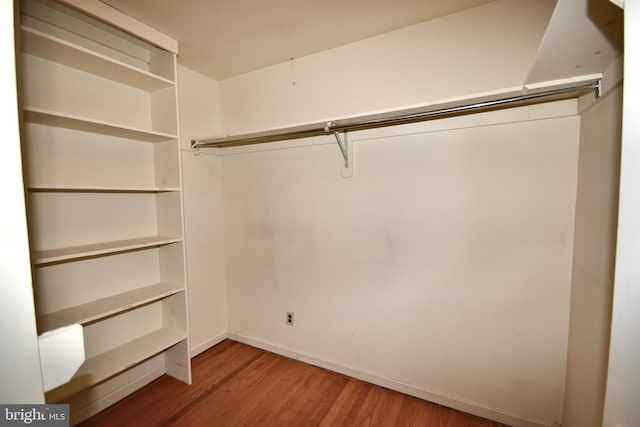 walk in closet with wood finished floors