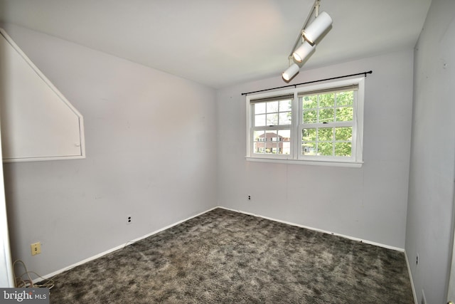 carpeted spare room featuring baseboards