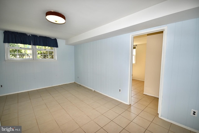 empty room featuring light tile patterned floors and baseboards
