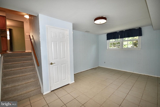 interior space with stairs, light tile patterned flooring, and baseboards