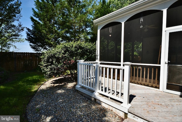 wooden deck with fence and a sunroom