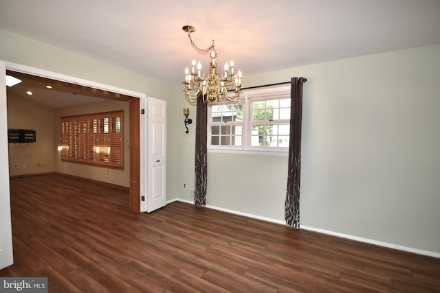 unfurnished dining area featuring baseboards, wood finished floors, and a chandelier