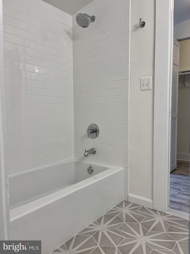 bathroom with tile patterned flooring, baseboards, and bathing tub / shower combination