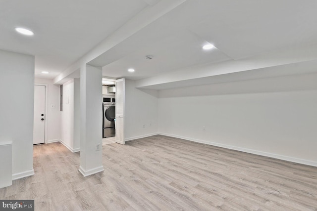 finished below grade area with baseboards, washer / dryer, light wood-style floors, and recessed lighting