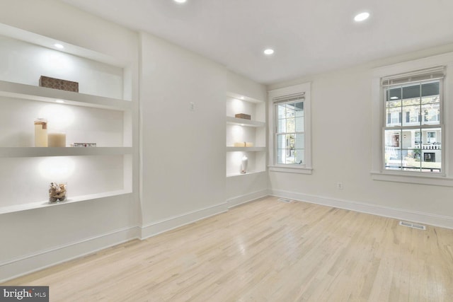 interior space with recessed lighting, wood finished floors, visible vents, baseboards, and built in features