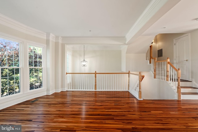 spare room featuring crown molding, wood finished floors, and visible vents