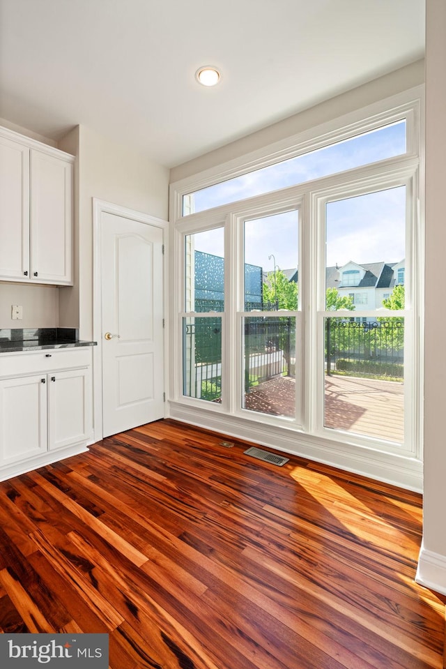 unfurnished dining area with visible vents, recessed lighting, and dark wood-type flooring