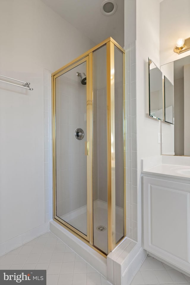 bathroom with a shower stall, tile patterned flooring, and vanity