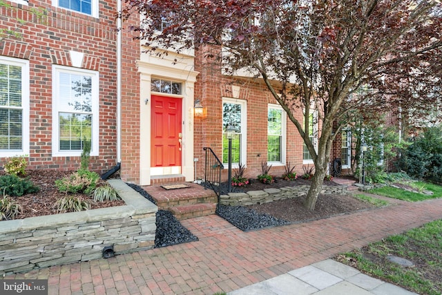 view of exterior entry featuring brick siding