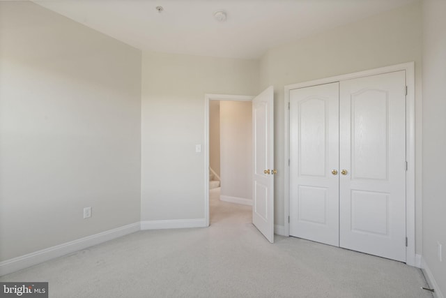 unfurnished bedroom featuring a closet, carpet flooring, and baseboards