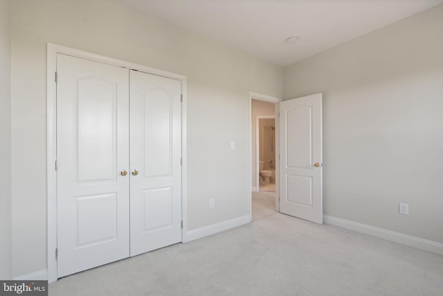 unfurnished bedroom with baseboards, carpet, and a closet