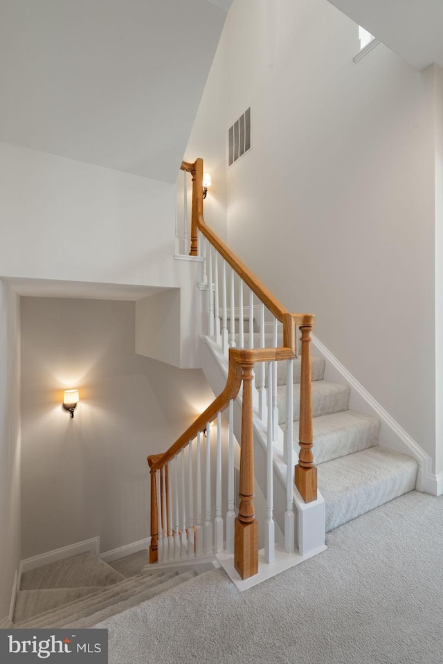 stairs featuring carpet floors, baseboards, and visible vents