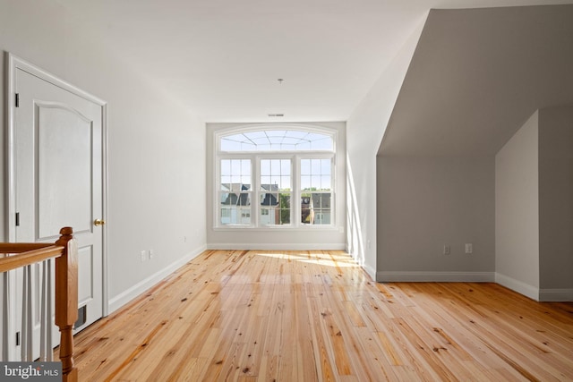 additional living space featuring baseboards and hardwood / wood-style flooring