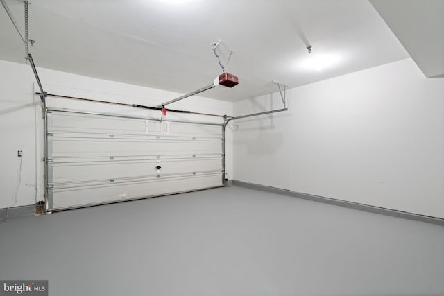 garage with baseboards and a garage door opener