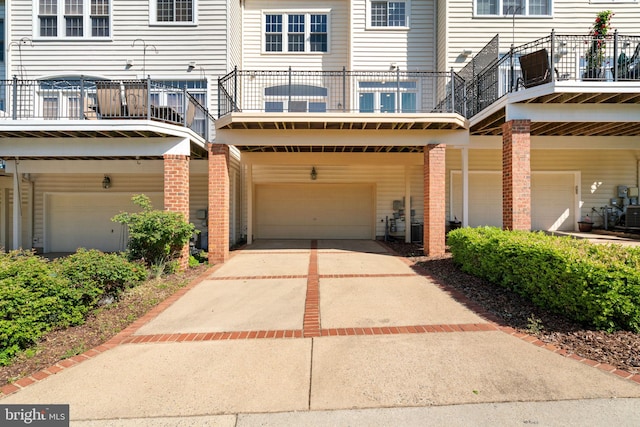 exterior space featuring brick siding, driveway, a balcony, and a garage