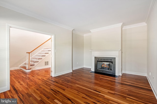 unfurnished living room with crown molding, a fireplace with flush hearth, stairs, and wood finished floors