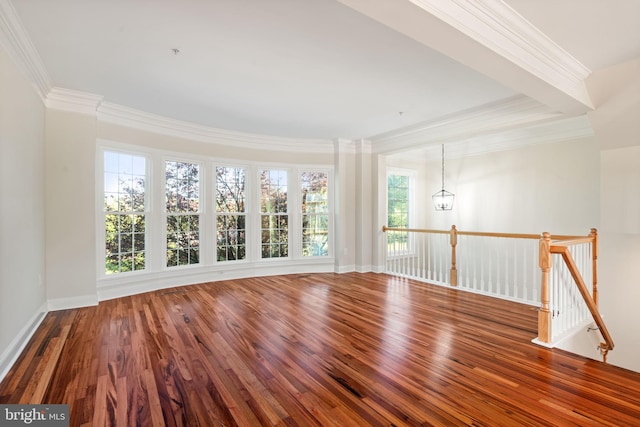 unfurnished room with crown molding, baseboards, wood finished floors, and a notable chandelier