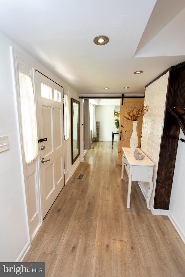 13909 Broomall Ln, Silver Spring, MD 20906 - entryway with a barn door, a wealth of natural light, light wood-style flooring, and visible vents