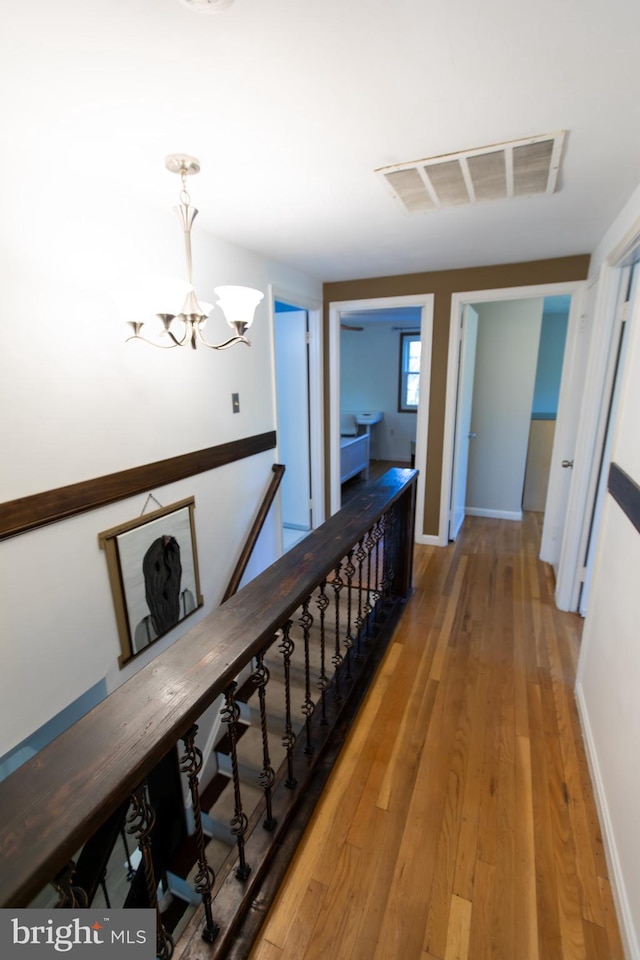 13909 Broomall Ln, Silver Spring, MD 20906 - hall featuring baseboards, a chandelier, wood finished floors, and visible vents