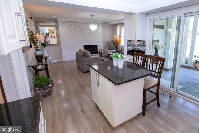 13909 Broomall Ln, Silver Spring, MD 20906 - kitchen with white cabinets, a fireplace, a breakfast bar, and a wealth of natural light