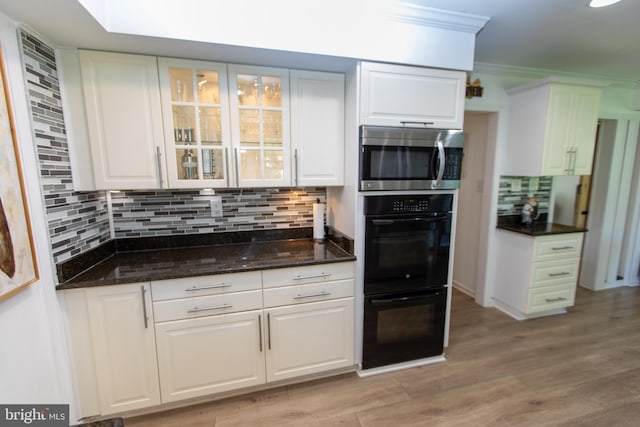 13909 Broomall Ln, Silver Spring, MD 20906 - kitchen with dobule oven black, stainless steel microwave, white cabinetry, and backsplash