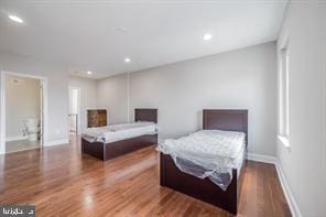 bedroom featuring wood finished floors, baseboards, and recessed lighting