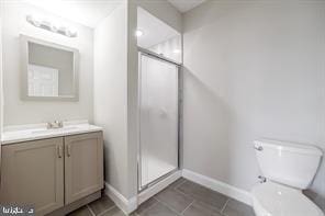 bathroom with tile patterned floors, toilet, a shower stall, and vanity