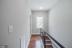 hallway with dark wood-style flooring and baseboards