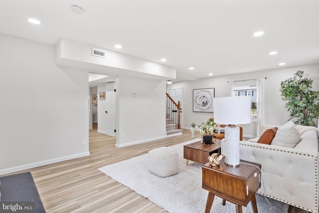living room featuring stairway, light wood finished floors, visible vents, and recessed lighting