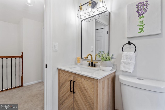 bathroom with a chandelier, toilet, and vanity