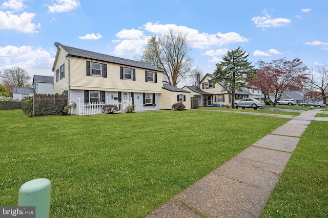 colonial inspired home with a front lawn and fence