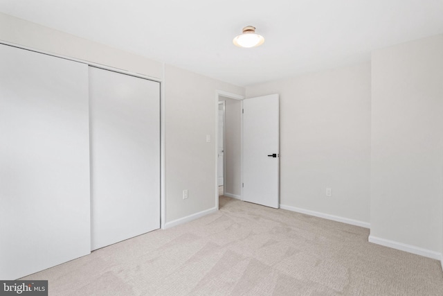 unfurnished bedroom with baseboards, a closet, and carpet