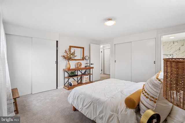 bedroom with light carpet and two closets