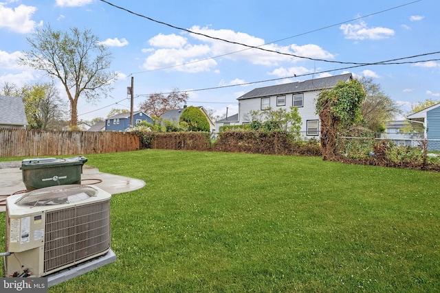 view of yard featuring central air condition unit and fence