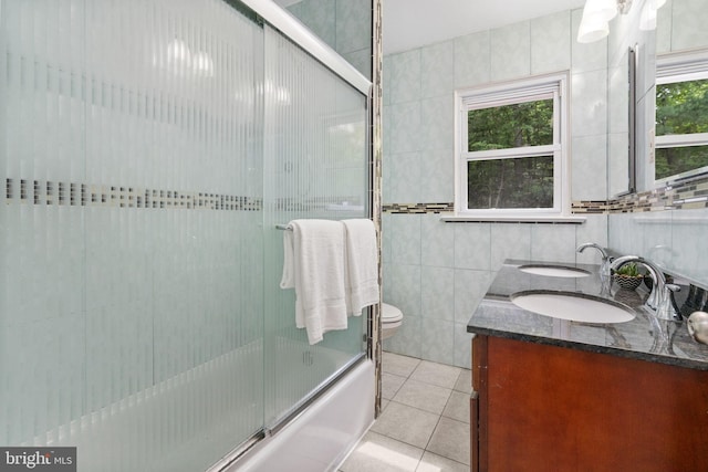 1302 Ashbridge Rd, West Chester, PA 19380 - bathroom featuring tile walls, tile patterned floors, double vanity, toilet, and combined bath / shower with glass door