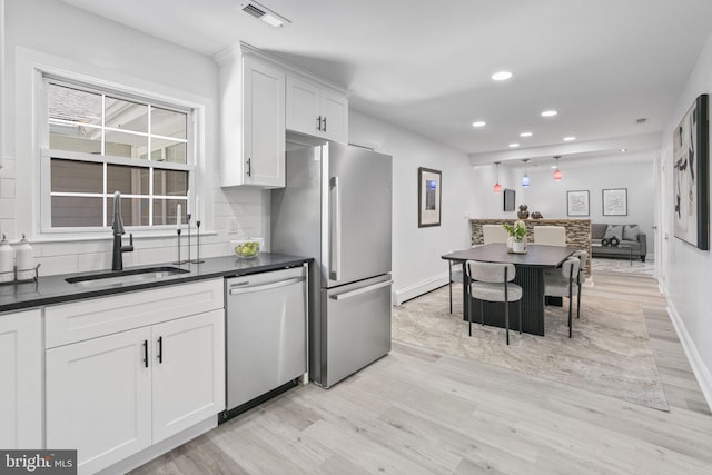 1302 Ashbridge Rd, West Chester, PA 19380 - kitchen with appliances with stainless steel finishes, a sink, light wood-style floors, dark countertops, and white cabinetry