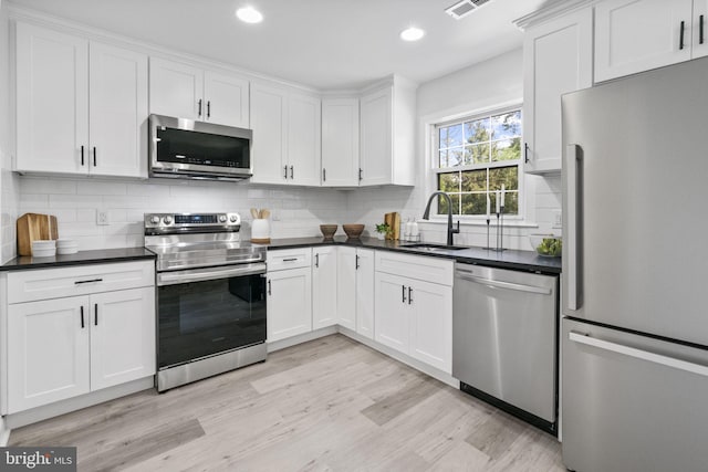 1302 Ashbridge Rd, West Chester, PA 19380 - kitchen with appliances with stainless steel finishes, a sink, dark countertops, light wood-style floors, and recessed lighting