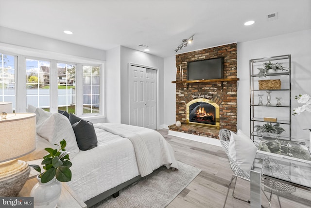 1302 Ashbridge Rd, West Chester, PA 19380 - bedroom with wood finished floors, a fireplace, a closet, rail lighting, and baseboards