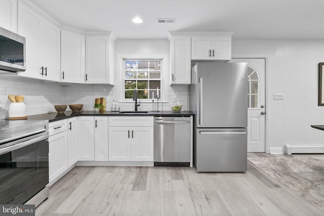 1302 Ashbridge Rd, West Chester, PA 19380 - kitchen with stainless steel appliances, light wood finished floors, a baseboard heating unit, white cabinetry, and tasteful backsplash