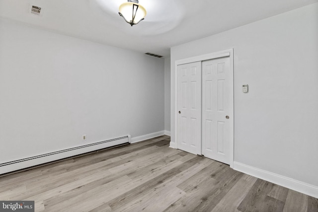 1302 Ashbridge Rd, West Chester, PA 19380 - unfurnished bedroom with baseboard heating, wood finished floors, a closet, and baseboards